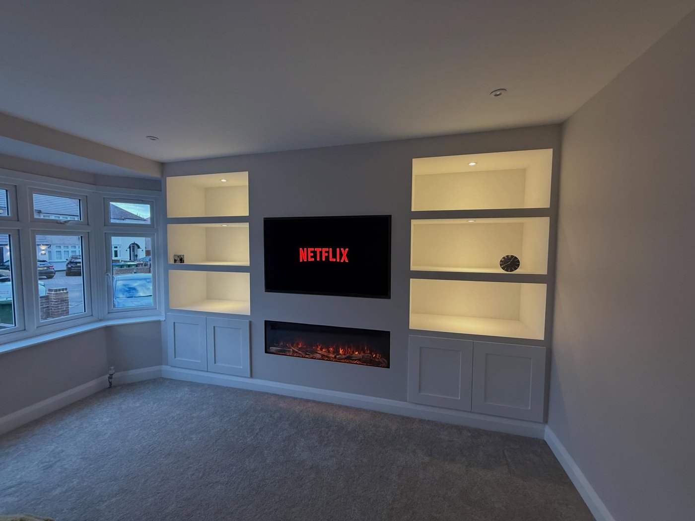 The finished media wall with an inset fire and a stone surround
