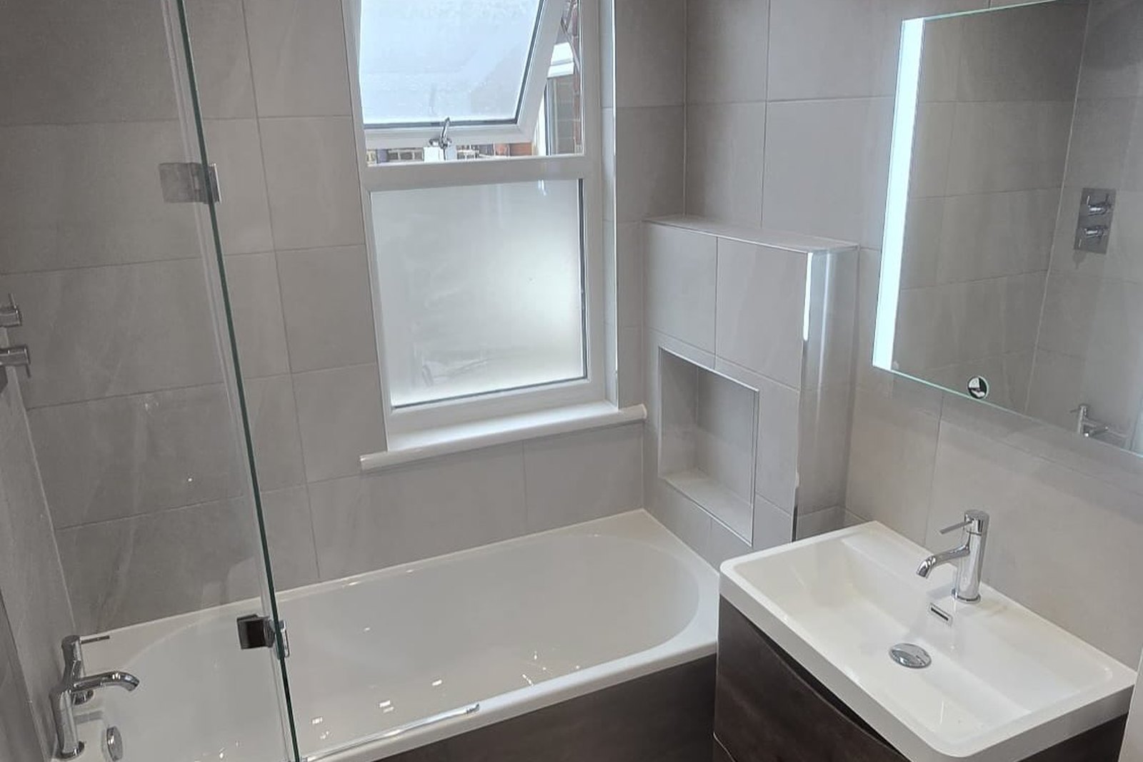 Refurbished bathroom in large format grey tiling