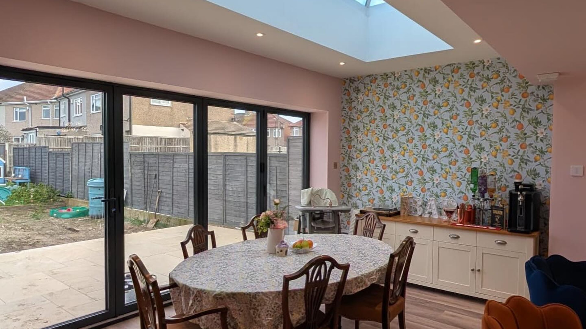Extension dining room under a roof lantern with bifold doors to the garden