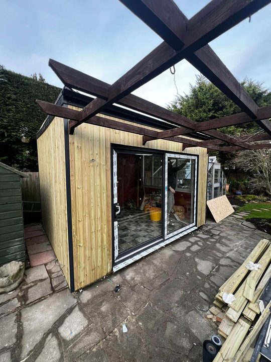 Timber framed extension under a pergola roof