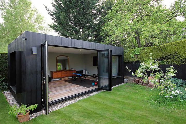 Dark clad garden room on a paved terrace