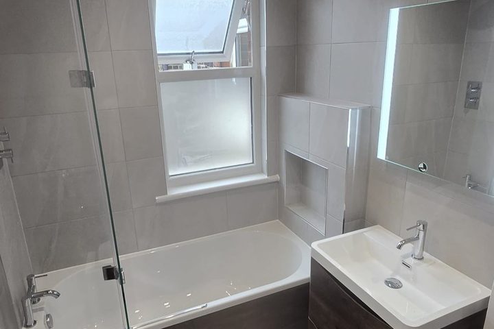 Refurbished bathroom in large format grey tiling