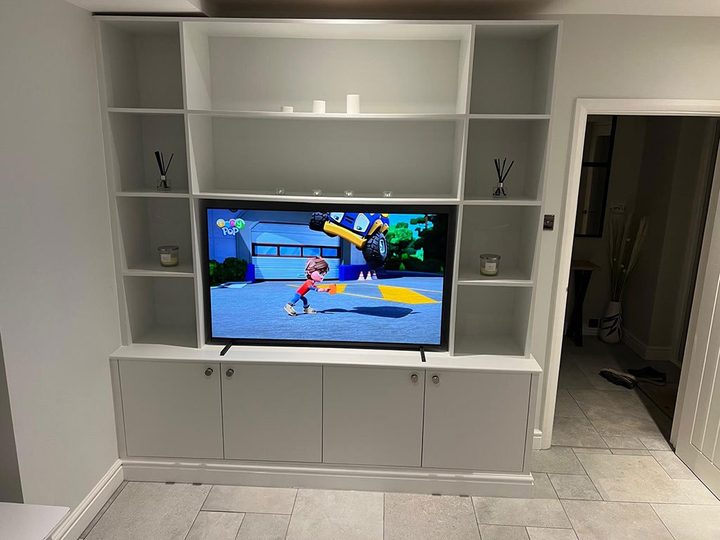 Alcove joinery with open shelves and cupboards either side of a screen