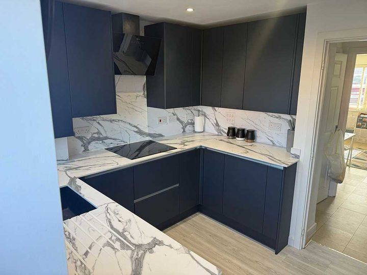 Renovated navy kitchen with marble worktops